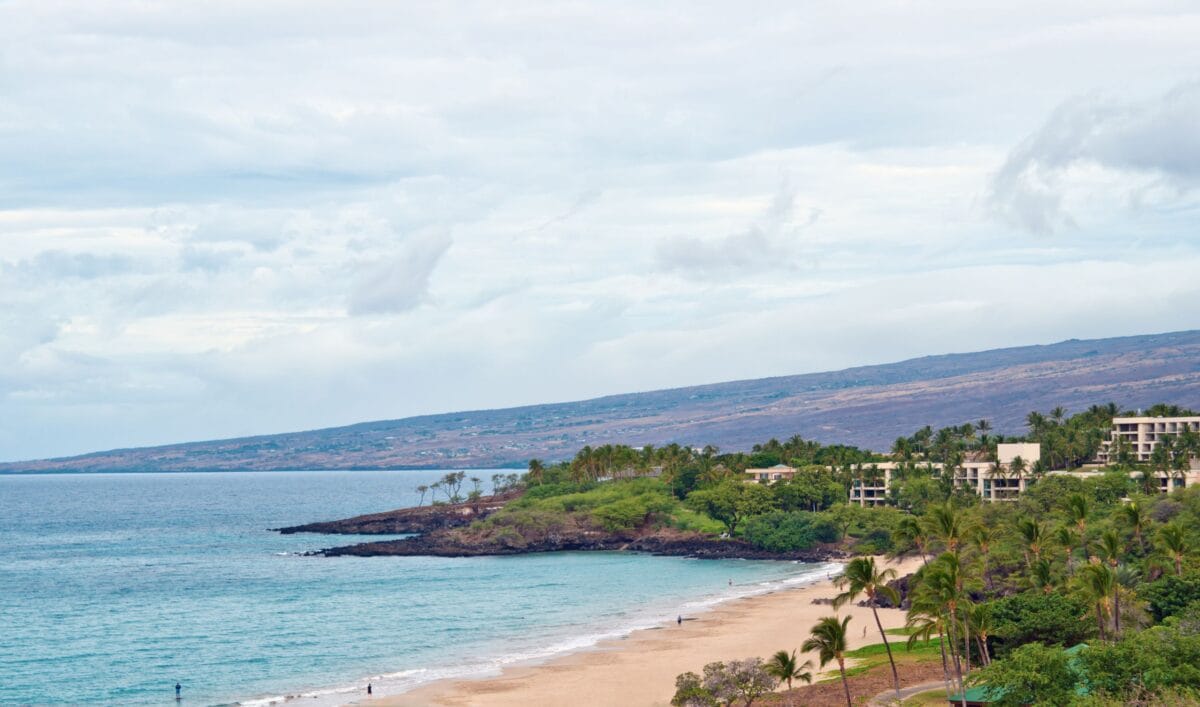 Aerial view of Hapuna Beach State Park and the Westin Hapuna Beach Resort on the Kohala Coast, featuring white sand, turquoise water, and mountain backdrop.