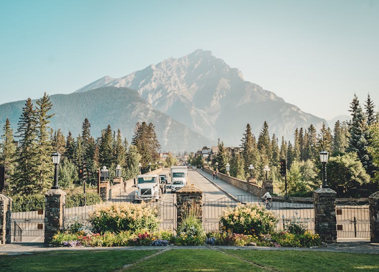 A picturesque view of Banff Avenue with a stunning mountain backdrop, showcasing nature and urban life.