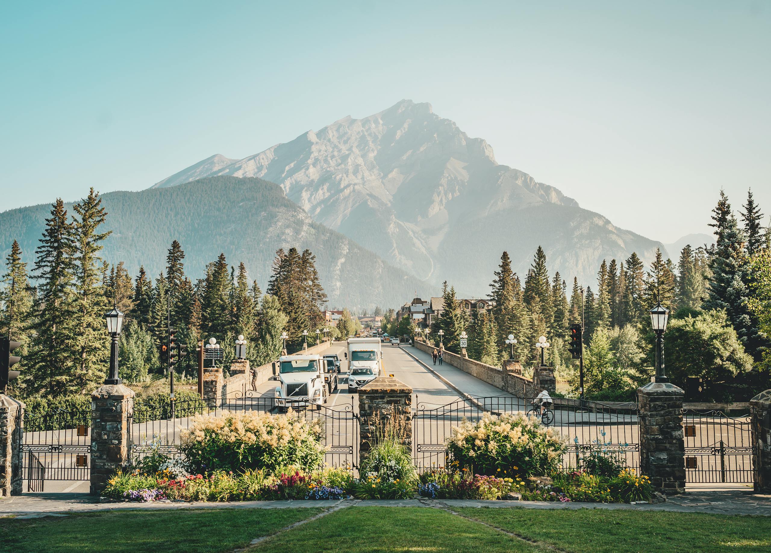 A picturesque view of Banff Avenue with a stunning mountain backdrop, showcasing nature and urban life.