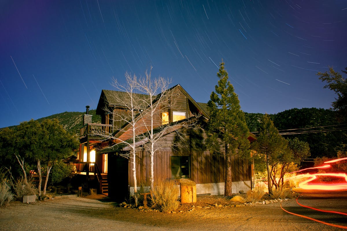 A serene night view of a cabin under a starlit sky in Pine Mountain Club, California.