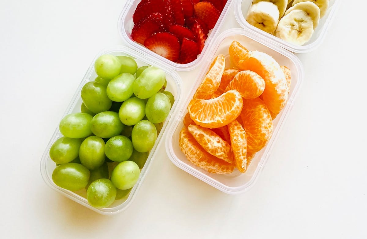 Bright and fresh fruits in containers, ideal for a healthy snack or meal prep.