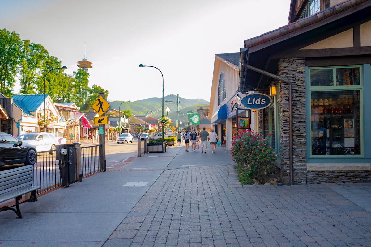 Where to Stay in the Smoky Mountains with Kids: Gatlinburg vs. Pigeon Forge 3 Quaint street scene in Gatlinburg, Tennessee with shops and distant mountains.